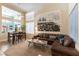 Open-concept living room with a comfortable leather sofa, dining area, and bright natural light at 2232 Le Conte Ave, Henderson, NV 89074