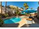 Enjoy a backyard featuring an inground pool, a built-in BBQ, patio seating, lush greenery and mature palm trees at 2232 Le Conte Ave, Henderson, NV 89074