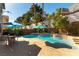 Inviting backyard features an inground pool, a spa, lounge chairs, lush greenery, and mature palm trees at 2232 Le Conte Ave, Henderson, NV 89074