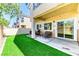 Inviting backyard featuring artificial grass, a covered patio, and access to the interior at 2264 Steamers Ave # 102, Las Vegas, NV 89183