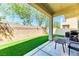 Private backyard area with artificial grass, a covered patio, and a peaceful outdoor setting at 2264 Steamers Ave # 102, Las Vegas, NV 89183