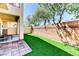 A serene outdoor living space with artificial turf complemented by a textured brick wall at 2264 Steamers Ave # 102, Las Vegas, NV 89183