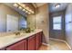 Well-lit bathroom featuring double sinks and a large mirror at 2264 Steamers Ave # 102, Las Vegas, NV 89183