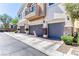 Three car garages are displayed with brick columns and stone trim on a two-story home exterior at 2264 Steamers Ave # 102, Las Vegas, NV 89183