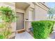 Inviting home entrance features a gray front door, neutral stucco exterior, and lush green landscaping at 2264 Steamers Ave # 102, Las Vegas, NV 89183
