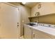 Functional laundry room with a modern washer, dryer, and convenient overhead shelving at 2264 Steamers Ave # 102, Las Vegas, NV 89183