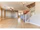 Spacious living room with tile flooring, a staircase, and a view into the modern kitchen at 2264 Steamers Ave # 102, Las Vegas, NV 89183