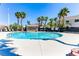Palm tree lined community pool features a metal hand rail entry and neighborhood houses at 2264 Steamers Ave # 102, Las Vegas, NV 89183