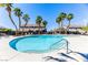 Community pool view showcasing deck with lounge chairs, palm trees and nearby neighborhood homes at 2264 Steamers Ave # 102, Las Vegas, NV 89183