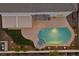 Aerial view of pool area with spa, covered patio, and fire feature at twilight at 2647 Hourglass Dr, Henderson, NV 89052