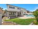 Beautiful backyard featuring a pool, patio, lush lawn, and mature landscaping at 2647 Hourglass Dr, Henderson, NV 89052