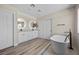 Modern bathroom featuring a soaking tub, dual sinks, white cabinetry, and wood look floors at 2647 Hourglass Dr, Henderson, NV 89052