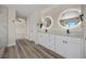 Bright bathroom features dual sinks, white cabinetry, granite countertops, and wood-look tile flooring at 2647 Hourglass Dr, Henderson, NV 89052