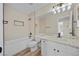 Bathroom featuring wood-look tile flooring, white cabinets, granite countertop and tub with tile surround at 2647 Hourglass Dr, Henderson, NV 89052