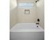 Clean, bright bathroom featuring a soaking tub, recessed lighting, and tiled walls at 2647 Hourglass Dr, Henderson, NV 89052