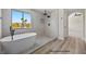 Modern bathroom featuring a luxurious soaking tub, tiled walls, and a glass shower at 2647 Hourglass Dr, Henderson, NV 89052