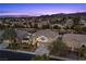 Two-story home with a three-car garage, well-maintained lawn, mature trees, and mountain views at 2647 Hourglass Dr, Henderson, NV 89052