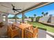 Relaxing covered patio with a ceiling fan, dining set, and view of the backyard and pool at 2647 Hourglass Dr, Henderson, NV 89052
