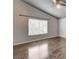 Bedroom with hardwood floors, a large window, and neutral paint, creating a cozy atmosphere at 2679 Regency Cove Ct, Las Vegas, NV 89121