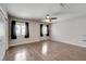 Bright bedroom with wood-look floors, a ceiling fan, two windows, and closet with sliding doors at 2679 Regency Cove Ct, Las Vegas, NV 89121
