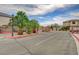 Community entryway featuring lush landscaping, palm trees, and decorative streetlamps at 2679 Regency Cove Ct, Las Vegas, NV 89121