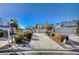 Neighborhood street view showcasing well-maintained homes, desert landscaping and long driveways under a clear blue sky at 2679 Regency Cove Ct, Las Vegas, NV 89121