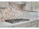 Contemporary kitchen backsplash featuring a mosaic tile pattern, complementing the stainless steel cooktop and cabinetry at 313 Forsyth Park St, Las Vegas, NV 89138