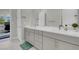 Well-lit bathroom with dual sinks, white countertops, and ample storage space with gray cabinetry at 313 Forsyth Park St, Las Vegas, NV 89138