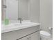 Sleek half-bathroom features a white vanity with gray cabinets, white walls, and modern fixtures at 313 Forsyth Park St, Las Vegas, NV 89138