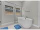 Bright bathroom featuring a freestanding tub and a window offering natural light at 313 Forsyth Park St, Las Vegas, NV 89138