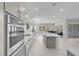 Modern kitchen featuring light gray cabinetry, stainless steel appliances, and a kitchen island connecting to living spaces at 313 Forsyth Park St, Las Vegas, NV 89138