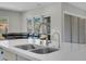 Modern kitchen island with sink and view into the living room featuring a sliding glass door and comfortable seating at 313 Forsyth Park St, Las Vegas, NV 89138