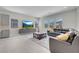 Spacious living room with modern furnishings, large windows, and an adjacent kitchen featuring stylish gray cabinetry at 313 Forsyth Park St, Las Vegas, NV 89138