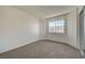 Sunlit bedroom with neutral carpet and a big window overlooking the complex at 3318 N Decatur Blvd # 2129, Las Vegas, NV 89130