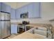 Modern kitchen boasts stainless steel appliances, granite counters, and blue cabinets at 3318 N Decatur Blvd # 2129, Las Vegas, NV 89130