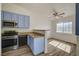 Bright kitchen features stainless steel appliances, blue cabinetry, and wood-look flooring at 3318 N Decatur Blvd # 2129, Las Vegas, NV 89130