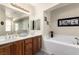 Bright bathroom featuring double sinks with a soaking tub for a luxurious experience at 3408 Livia Ave, North Las Vegas, NV 89031