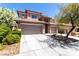 Two-story home featuring a tile roof, stone accents, a two-car garage, and desert landscaping at 3408 Livia Ave, North Las Vegas, NV 89031