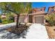 Two-story home featuring a tile roof, stone accents, a two-car garage, and desert landscaping at 3408 Livia Ave, North Las Vegas, NV 89031