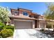 Two-story home featuring a tile roof, stone accents, a two-car garage, and desert landscaping at 3408 Livia Ave, North Las Vegas, NV 89031