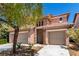 Two-story home featuring a tile roof, stone accents, a two-car garage, and desert landscaping at 3408 Livia Ave, North Las Vegas, NV 89031