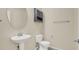 This bathroom has a pedestal sink, an oval mirror, a toilet, a towel bar, and a small wall mounted cabinet at 3638 Via Messina, Henderson, NV 89052