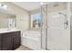 This bathroom features a glass shower door, a tub, a large window, a vanity and modern shower fixtures at 3638 Via Messina, Henderson, NV 89052