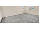 An empty bedroom with two windows, neutral walls, plush grey carpet, and white baseboards at 3638 Via Messina, Henderson, NV 89052