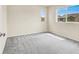 This bedroom features neutral walls, plush gray carpet, and two large windows with views of neighboring homes at 3638 Via Messina, Henderson, NV 89052
