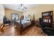 Comfortable bedroom with hardwood floors, a ceiling fan, and a large desk for a home office at 3955 W Jo Rae Ave, Las Vegas, NV 89141