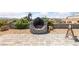 Unique backyard stone fireplace with a steel dragon art piece, surrounded by desert landscaping at 3955 W Jo Rae Ave, Las Vegas, NV 89141