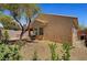 Exterior view of backyard with a small tree, barbecue, and tan stucco wall at 4037 Vulcan St, Las Vegas, NV 89122