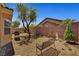 Spacious backyard featuring gravel landscaping, grill, bench, and trees at 4037 Vulcan St, Las Vegas, NV 89122