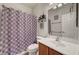 Cozy bathroom with a modern sink, toilet, and shower with patterned curtain at 4037 Vulcan St, Las Vegas, NV 89122